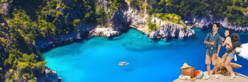 Couple enjoying a scenic view of a secluded turquoise bay surrounded by lush cliffs during an all-inclusive holiday in Antalya, Türkiye.