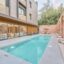 Elegant outdoor pool area at La Maja Hotel Antalya, featuring sun loungers, tropical umbrellas, and modern architectural design