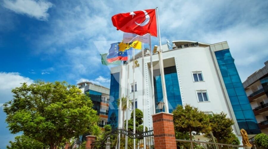 Outside view of Onkel Rada Apartment in Antalya for rent with Turkish flag and modern architecture