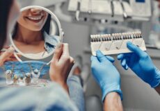 Woman choosing tooth shade at a dental clinic in Antalya, Türkiye, while envisioning a relaxing beach vacation - perfect blend of dental care and holiday.