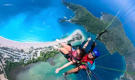 Tandem paragliding over Oludeniz, Turkey, showcasing the Blue Lagoon and coastline – explore paragliding Oludeniz Turkey prices starting at $150 with Antalya Activities